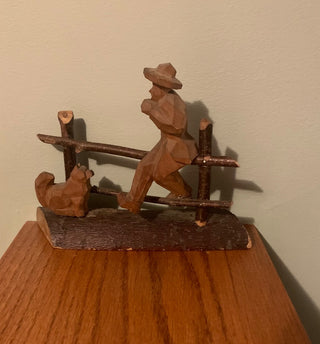 wood carving dog w/man on fence
