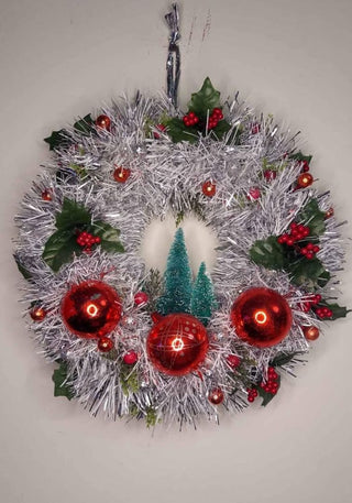 Midcentury mercury glass wreath with vintage red ornaments, mistletoe Holly Berry, bottle brush trees on silver, white tinsel