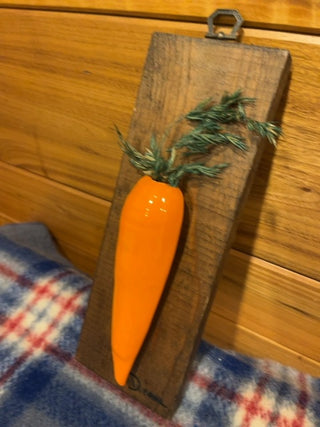 Ceramic carrot on wood