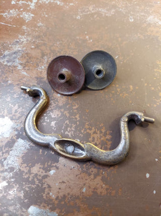 Chippendale-style antique brass tone metal swan neck bail pull drawer handle, with replacement decorative rosettes