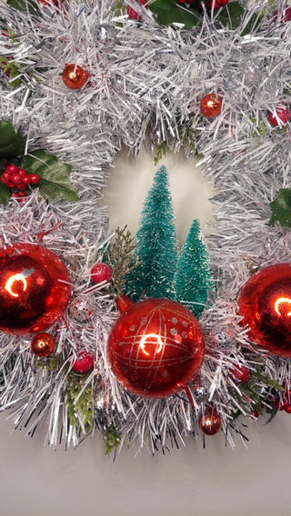 Midcentury mercury glass red ornaments with mistletoe Holly Berry and bottle brush trees on silver and white tinsel wreath