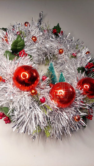 Midcentury mercury glass red ornaments with mistletoe Holly Berry and bottle brush trees on silver and white tinsel wreath