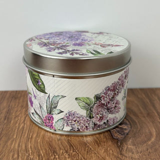 Round tin can with floral design on wooden surface
