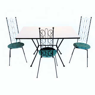 Outdoor table and chairs set with decorative metal design on a white background