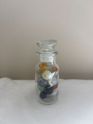 small glass jar with marbles