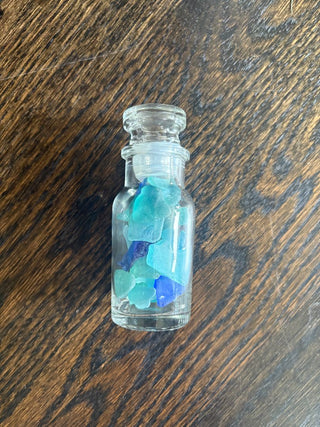 small glass jar with blue seaglass