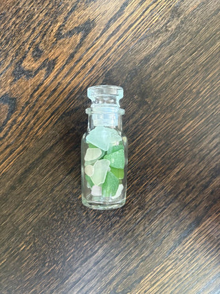 small glass jar with green seaglass