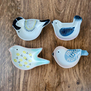 Bring charm to any space with a hand-painted stoneware bird dish. Perfect for jewelry, keys, or décor. Available in 4 whimsical assorted styles.
