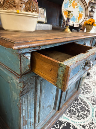 distressed blue antique sideboard with a wooden top and hutch.